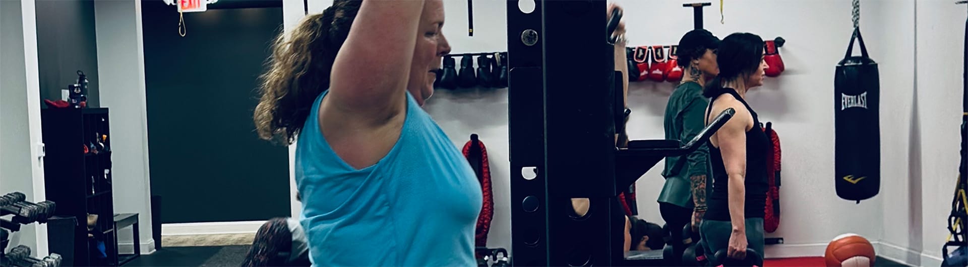 woman lifting weights and exercising at CoreFit Training Studio